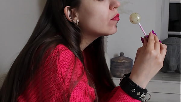 A Honey In Leather Handcuffs Licks A Candy