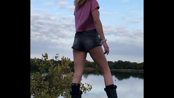 Breathtaking Fair-haired Model With Minuscule Shorts With Flawless Booty Posing For Pictures On A Rock Overlooking The Lake