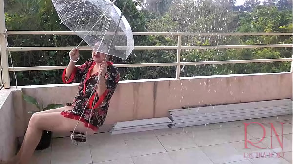 The Miss Is Swinging On A Rope Swing, Hiding From The Rain Under An Umbrella.